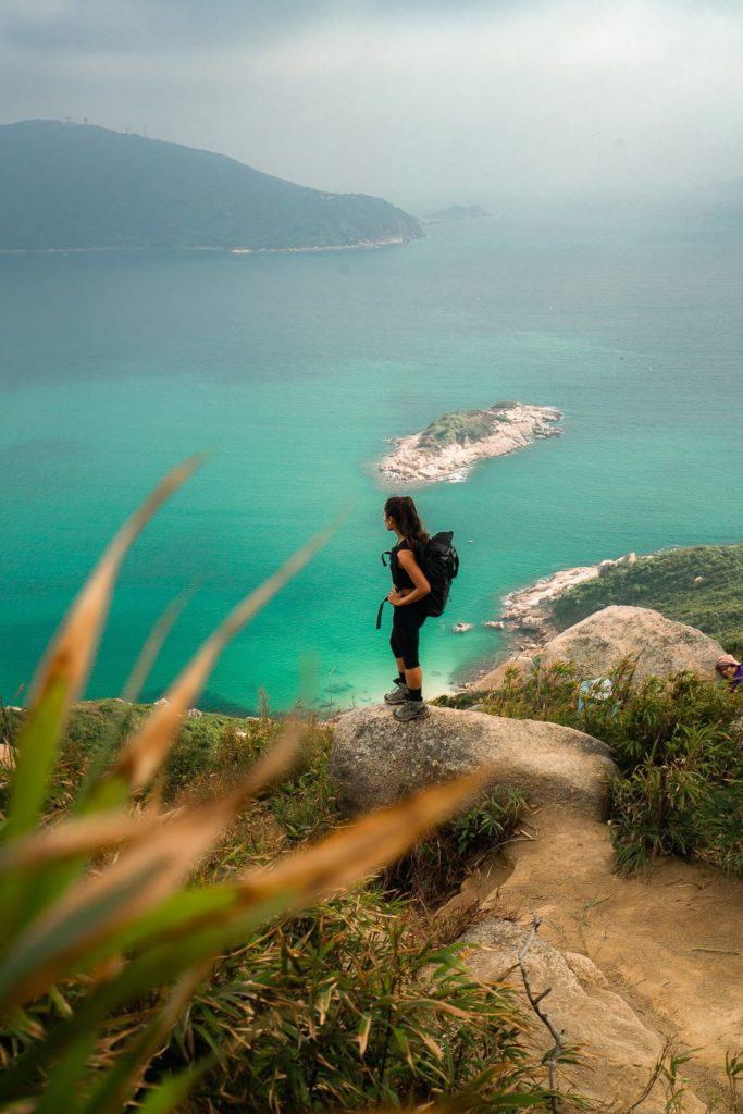 海の隣の岩の上に立つ女性。