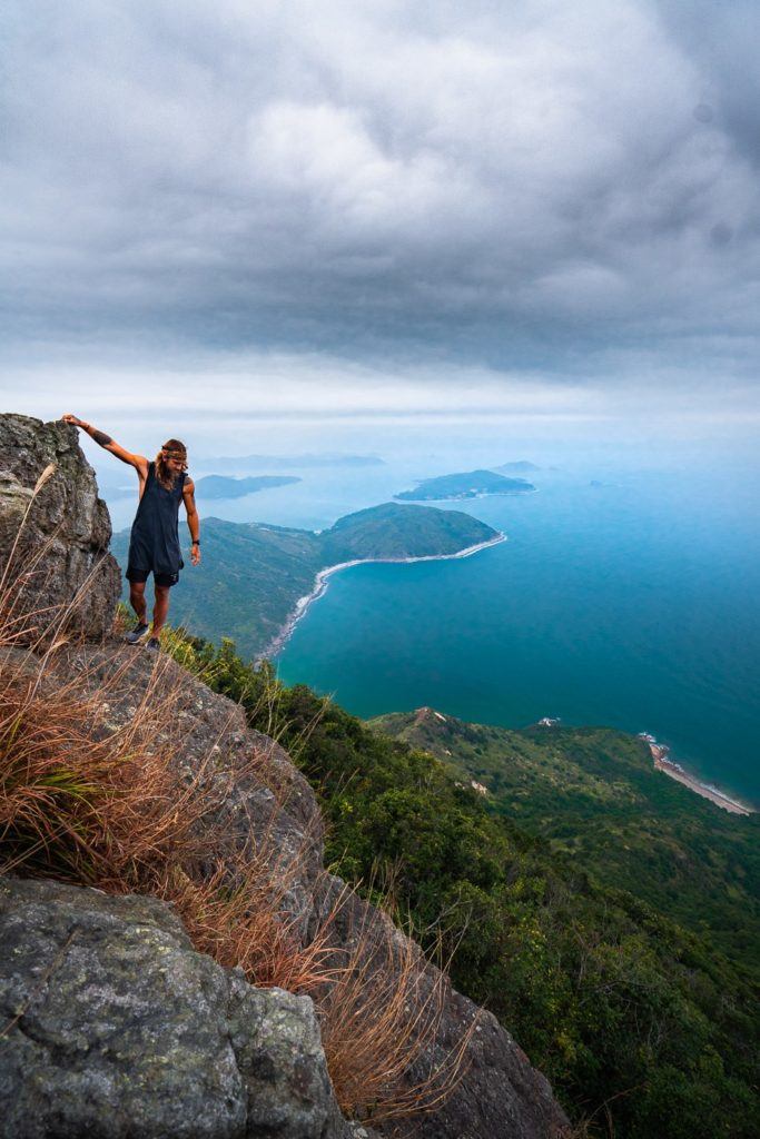 岩だらけの崖の上に立つ女性。