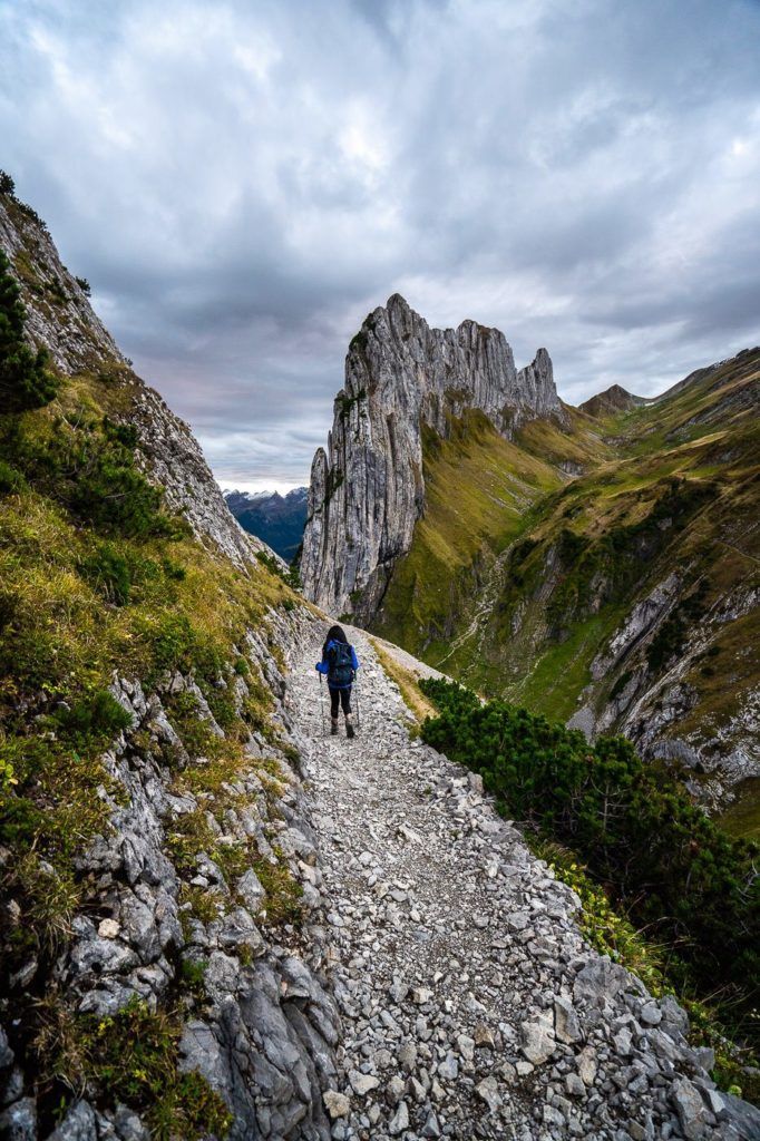 山の中の岩だらけの道を歩いている人。
